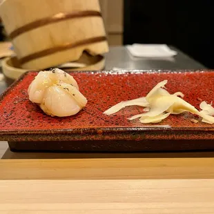 a red plate with two pieces of garlic on it