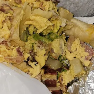 The demise of a sad mushy breakfast burrito too stuffed with lots of egg, undercooked potatoes, cheese, rubbery bacon and avo.