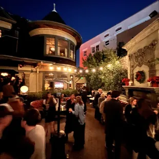 a crowd of people walking down a street at night
