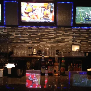 a bar with multiple televisions on the wall