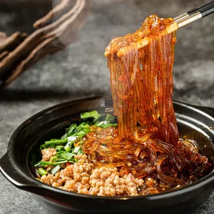 a bowl of noodles with chopsticks