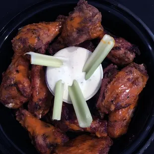 a bowl of chicken wings and celery sticks