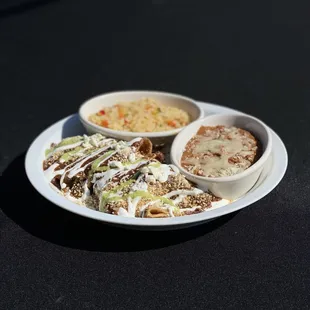 Enmoladas, a traditional Mexican dish served with rice and beans.