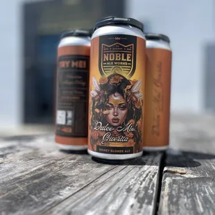 two cans of beer on a wooden table