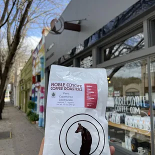 a hand holding a bag of coffee roasters