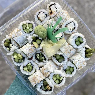 a plastic container of sushi
