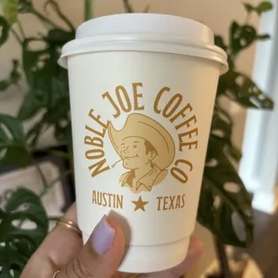 a hand holding a cup of coffee
