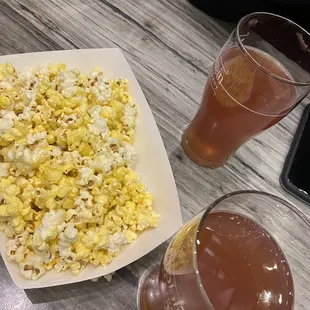 a plate of popcorn and a glass of beer