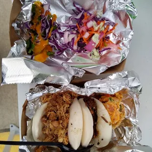 Chicken and brisket baos with side of their corn bread and slaw toppings on side (top dish)