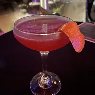 a pink cocktail in a coupe glass