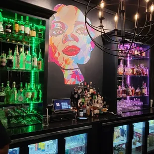 a woman&apos;s face on the wall behind the bar