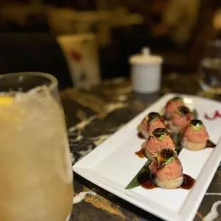 a plate of sushi and a drink on a table