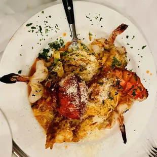 a plate of pasta with shrimp and vegetables