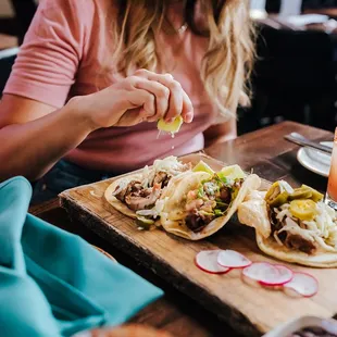 a woman sitting at a table with food