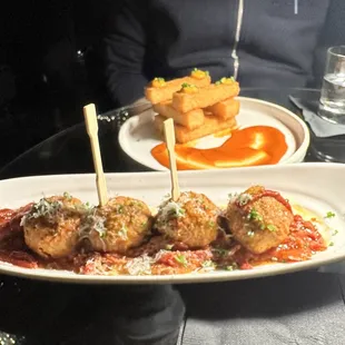 a plate of meatballs on a stick