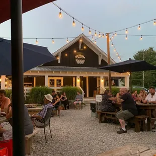 a group of people sitting at tables under umbrellas