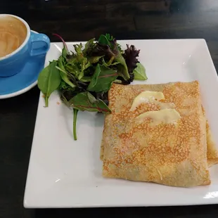 A cappuccino with a Smoked salmon crepe with salad.