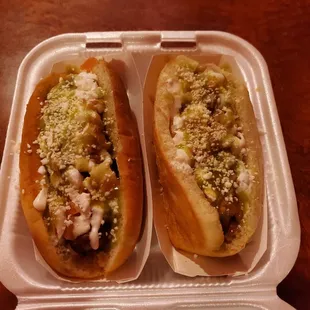 two hot dogs in a styrofoam container