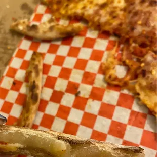 a hand holding a piece of pizza