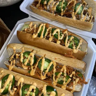 three hot dogs with toppings