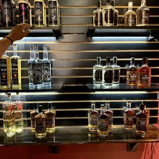 a man standing in front of a wall of liquor bottles