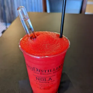 a red drink in a plastic cup