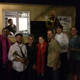 The amazing NOLA Girl serves as the backdrop to the motley birthday crew before dinner is served.