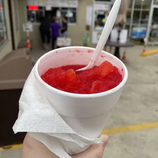 a hand holding a cup of ice cream