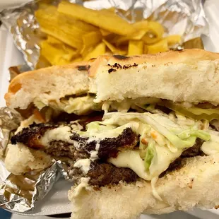 Nolanica Burger: beef patty dressed w/fried cheese, sweet plantains, vinaigrette slaw, Nola Nica sauce on toasted coconut bread.