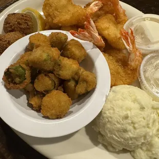 a plate of fried shrimp, mashed potatoes, and mashed potatoes
