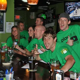 a group of people wearing green shirts