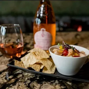 a bowl of chips and a glass of wine