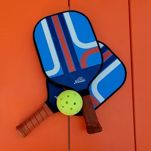 a pickle ball and two paddles