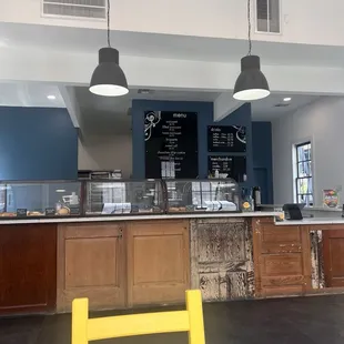 a view of a restaurant counter with a yellow chair in front of it