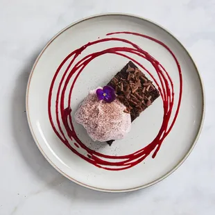 A white plate topped with a piece of chocolate cake and ice cream.