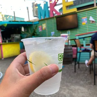 a hand holding a cup of lemonade