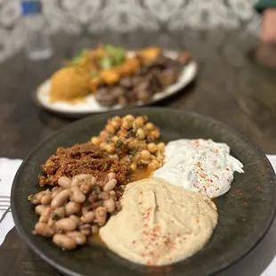 Appetizer plate with hummus, chickpeas, beans, yogurt sauce and pepper paste sauce