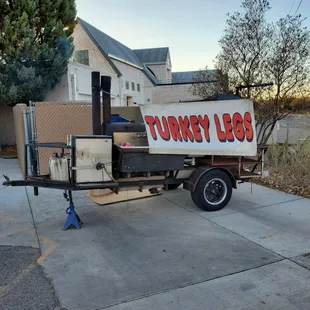 a turkey bbq trailer parked in front of a house