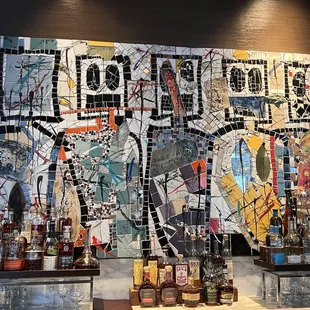 a mosaic of liquor bottles on a bar counter