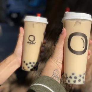 a person holding two cups of coffee