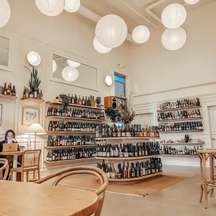 a woman sitting at a table in a wine shop