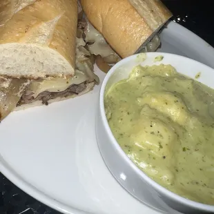 Steak sandwich with creamy pesto sauce over cheese raviolis