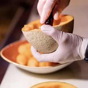 a person holding a cantaloupe