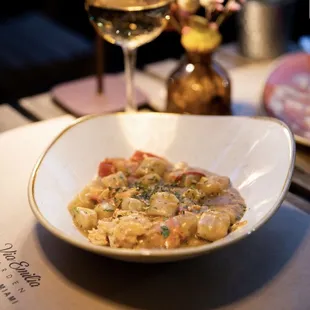 a bowl of pasta and a glass of wine
