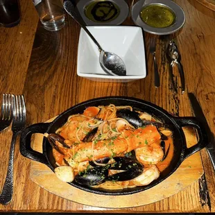 Cioppino - Mussels, crab leg, scallops, shrimp and clams in spicy tomato broth over spaghetti pasta.