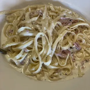 a bowl of pasta with ham and cheese