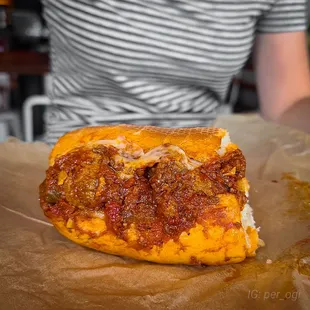 a person sitting at a table with a sandwich