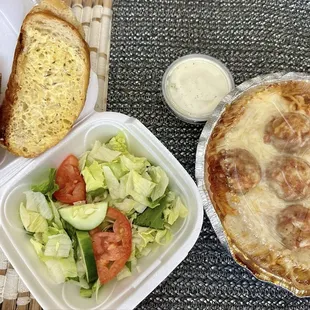 Spaghetti and meatballs with side salad and garlic bread