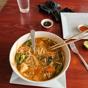 a bowl of soup with chopsticks