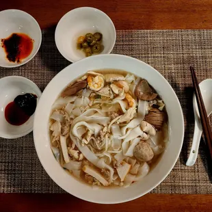 a bowl of noodle with chopsticks